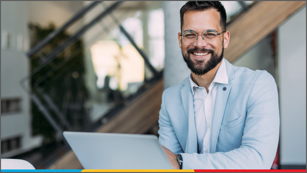Smiling business man at desk with laptop